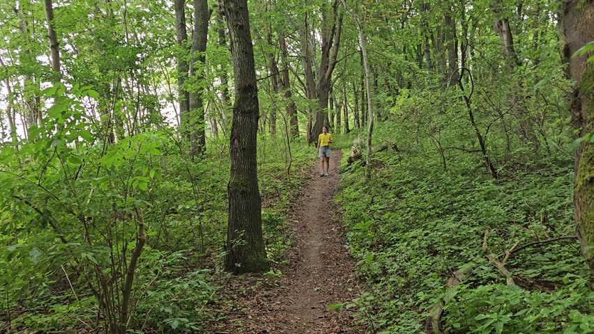 Forest muddy path from zealots, woman walking through the forest, off-road cycling, family traveling through wooded area, swampy land