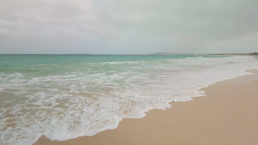 Atlantic Ocean waves breaking on an empty sand beach on the Cape Verde island of Boa Vista.
