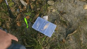 Careful owner pushing his curious dog away from a dangerous tackle box full of sharp fishing lures with hooks while preparing his spinning rod for catching fish in the wilderness during autumn - Powered by Shutterstock - Get 15% off with code: PIKWIZARD15