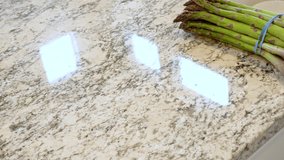 Large organic asparagus stalks are being sliced in a modern white kitchen, in preparation for steaming. - Powered by Shutterstock - Get 15% off with code: PIKWIZARD15