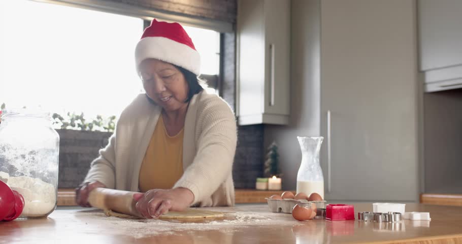 Senior home baker rolling dough and displaying animated social media bar showing rising followers. Holiday, celebration, festive, culinary, traditional, cozy, social media