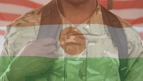 Soldier gripping backpack strap initiating Nigerien flag overlay while displaying American flag. Patriotism, unity, sacrifice, resilience, determination, military, symbolism - Powered by Shutterstock - Get 15% off with code: PIKWIZARD15