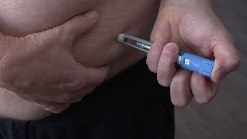 Man injects semaglutide from injector pen into belly fat for diabetes
