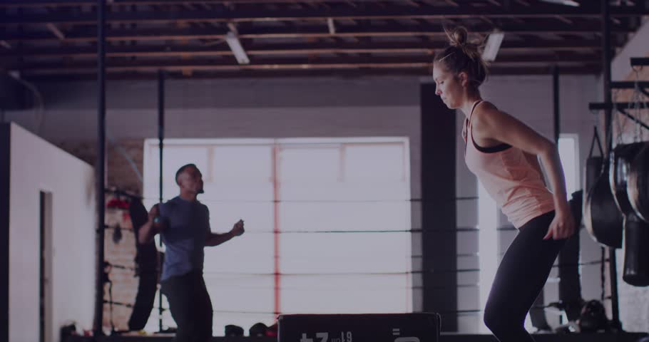Upon man starting rope skipping and woman stepping onto plyo box performing jumps for gym training. Fitness, exercise, strength, cardio, endurance, athletic, training