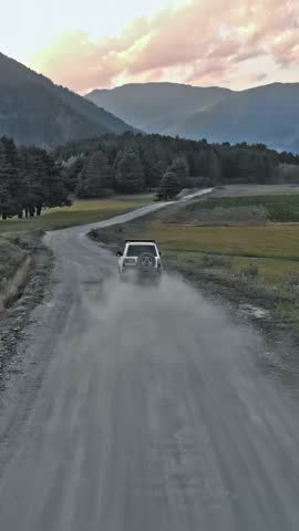 Aerial over off road 4x4 car driving along gravel trail path