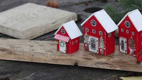 Charming Christmas houses: Close-up of decorative red houses with white roofs creating a festive winter holiday village on a wooden surface, perfect for seasonal decor - Powered by Shutterstock - Get 15% off with code: PIKWIZARD15