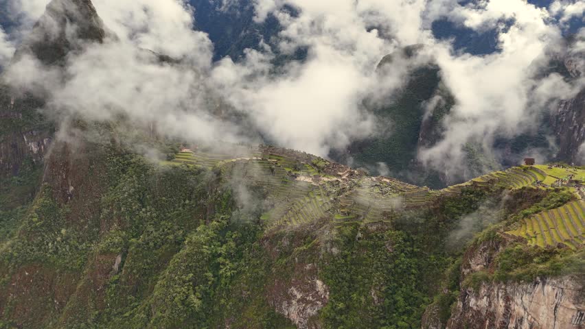 Flies over main city gate of Machu Picchu, circling sacred heart of citadel. It weaves in and out of misty clouds, dramatically revealing Temple of Sun, Royal Tombs, Ritual Fountains and Royal Palace