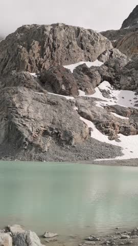 Serene Glacial Lake Reflects Majestic Rocky Mountains with Snow Patches in British Columbia, Canada