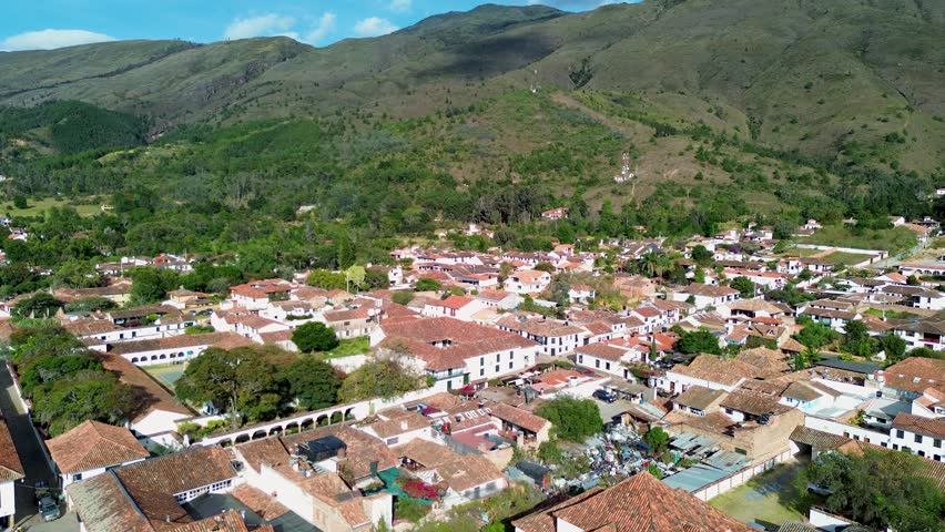 Villa de Leyva aerial view from park, Colonial Colombian town with mountain background, Drone flight over historic white village. High quality 4k footage