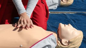 Cardiopulmonary resuscitation (CPR) training demonstration showing paramedic performing chest compressions on adult CPR dummy during first aid course - Powered by Shutterstock - Get 15% off with code: PIKWIZARD15