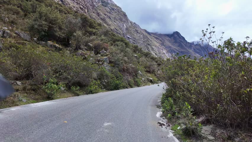 Huaraz, Peru: Point of view footage of riding motorcycle on the road to Punta Olimpica in Huascaran National Park, Peru under dramatic sky 