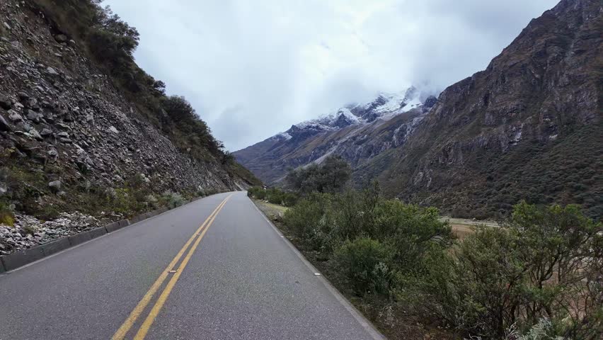 Huaraz, Peru: Point of view footage of riding motorcycle on the road to Punta Olimpica in Huascaran National Park, Peru under dramatic sky 