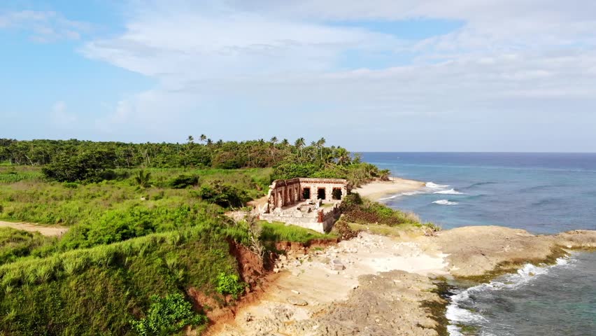blue sky, clouds, aerial (drone) view of the ruins of the Spanish lighthouse at Punta Borinquen beach, Aguadilla, Puerto Rico	