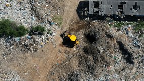 Overhead drone shot of a heavy equipment excavator working at a massive municipal solid waste (MSW) landfill, digging a cell for trash disposal. 4K timelapse. - Powered by Shutterstock - Get 15% off with code: PIKWIZARD15