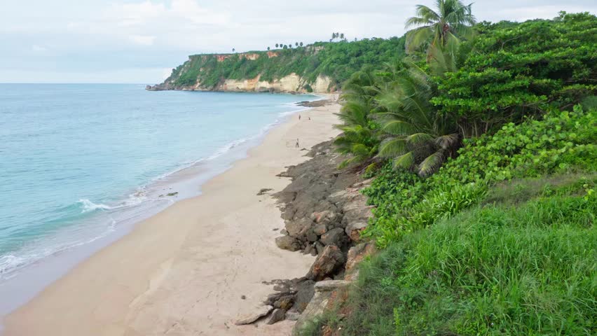 Aerial view of Punta Borinquen tropical beach, blue sea, green clift and quiet afternoon