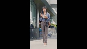 Young happy businesswoman walking outdoor for business travel, modern office buildings forming a sleek backdrop, enjoying urban activity, confident stride for daily tasks, successful career path. - Powered by Shutterstock - Get 15% off with code: PIKWIZARD15