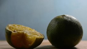 Close-up of Fresh Green Lime or Calamansi Fruit, One Whole and One Squeezed Half, on a Light Wooden Table with Water Droplets - Powered by Shutterstock - Get 15% off with code: PIKWIZARD15