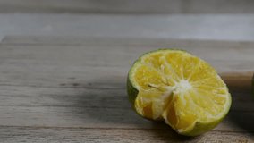 Close-up of Fresh Green Lime or Calamansi Fruit, One Whole and One Squeezed Half, on a Light Wooden Table with Water Droplets - Powered by Shutterstock - Get 15% off with code: PIKWIZARD15