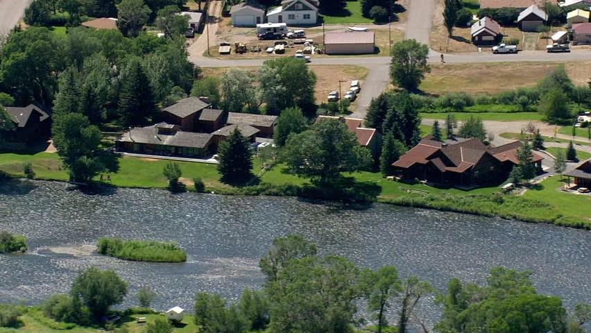 Aerial view of houses along a river in a rural town on a sunny summer day