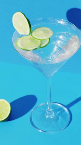 Animation of party text over cocktail glass on blue background. Party, festivity, celebration and entertainment concept digitally generated video.