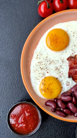 Fried egg, bacon and beans, a classic British breakfast with tomatoes. Egg, bacon and beans