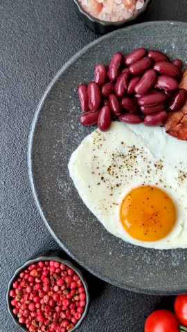 Fried egg, bacon and beans, a classic British breakfast with tomatoes. Egg, bacon and beans