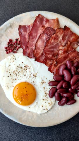 Fried egg, bacon and beans, a classic British breakfast with tomatoes. Egg, bacon and beans