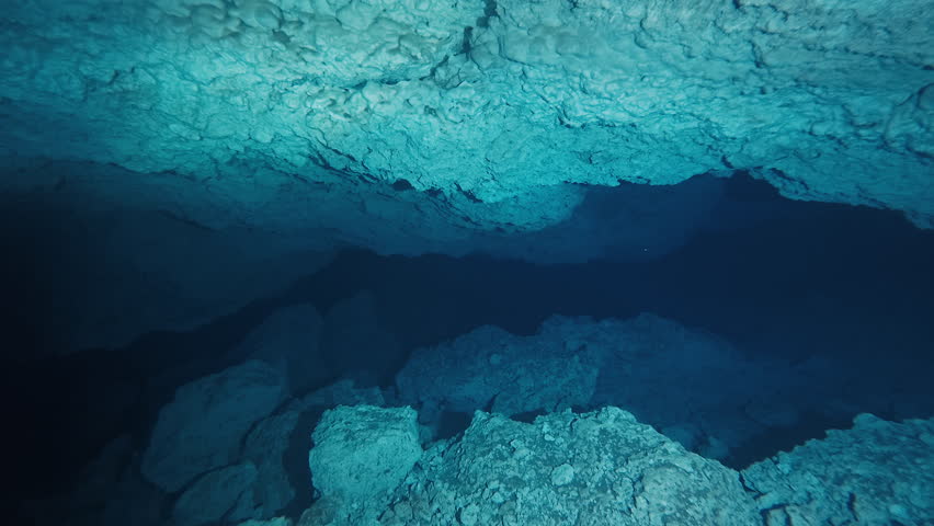 Underwater cave. Camera moves forward in the underwater limestone cave with crystal clear water and blue walls