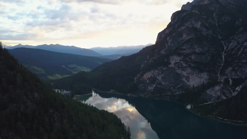 Aerial view of Braes Lake surrounded by mountains and forests at dusk