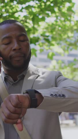 Animation of notification bars, african american man looking at smartwatch while talking on phone. Digital composite, multiple exposure, business, social media reminder and technology concept.