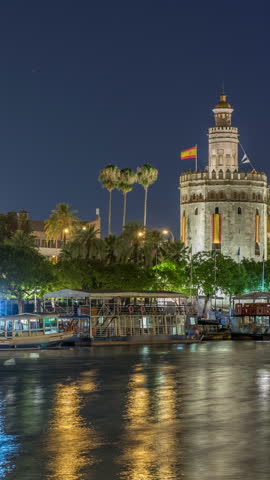 Torre del Oro timelapse hyperlapse, a dodecagonal military watchtower in Seville, Spain. Built by the Almohads to control Guadalquivir River access. Historic landmark with reflections at night.