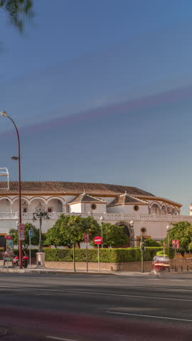 Plaza de Toros de la Real Maestranza de Caballeria de Sevilla timelapse hyperlapse. Historic bullring in Seville, Spain, known for its bullfighting festivals. Traffic passing in front of its facade