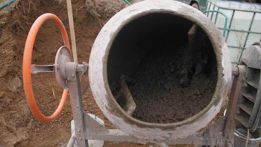 efficient concrete mixing in drums, rotating drum blends concrete thoroughly and efficiently, closeup of concrete mixer demonstrating thorough and uniform blending process inside rotating