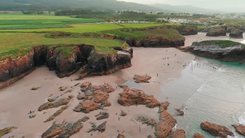 Amazing aerial view of the Playa de Las Catedrales beach in Galicia region at sunset, northern Spain. Beautiful cliff formations on famous Cathedral Beach, Cantabrian Coast 