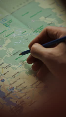 A person is studying a map while writing notes to plan future travel. This moment captures the excitement of preparing for exploration in a serene location