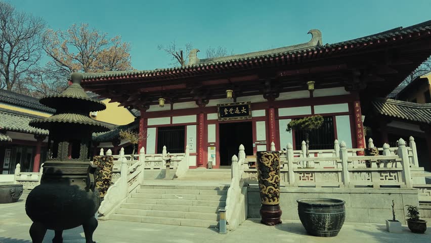 Nanjing, China. A traditional Chinese temple with ornate architecture and red and white walls. The temples entrance is marked by a large, ornate lantern.