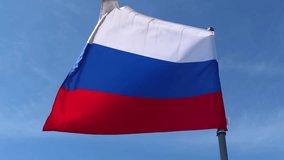 National flag of the Russian Federation waving in the wind against a clear blue sky, symbolizing patriotism and national pride on a sunny day. A patriotic and official banner of the country - Powered by Shutterstock - Get 15% off with code: PIKWIZARD15