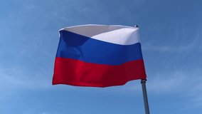 National flag of Russia with its white, blue, and red horizontal stripes waving proudly on a flagpole against a beautiful clear sky, symbolizing the country's patriotism and sovereignty - Powered by Shutterstock - Get 15% off with code: PIKWIZARD15