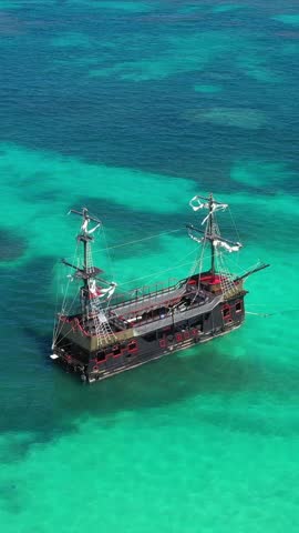Pirate ship floating in caribbean sea. It is popular excursion for tourists. Dominican Republic. Aerial top view. Vertical footage