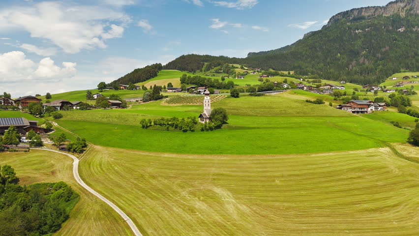 Farm road leading to Chiesa di San Valentino with fields on both sides, aerial view. Rural access to a historic church