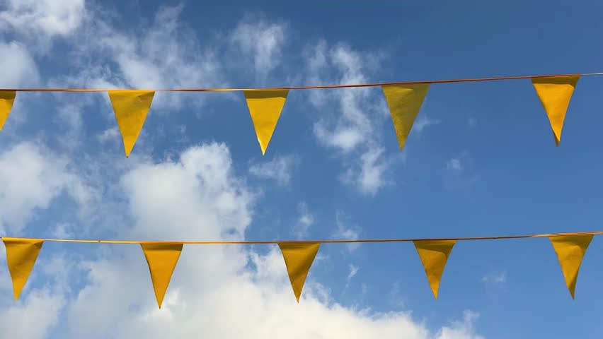 Close-up of yellow flags on a string, fluttering at a festive fair, vibrant and playful decor capturing autumn celebration vibes, bright carnival atmosphere
