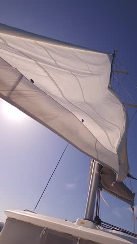 Sailing trip. Moments on the yacht. Relaxing on the bow. Furling the sail.