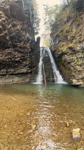 Ukraine, Carpathian Mountains, a small waterfall in an orange autumn forest near a large waterfall Bukhtivets, Pasichna village, Nadvirna city