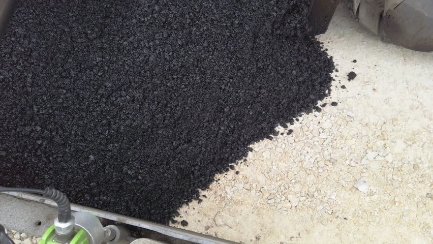 Road construction. Asphalt pavement machine making new layer of asphalt. Abstract view from above.