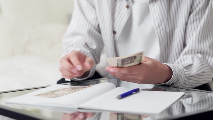 Asian man counting money in the living room