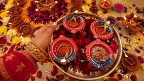 Closeup of young woman hand holding plate of burning colourful diyas during Diwali festival celebration. Festival of lights. - Powered by Shutterstock - Get 15% off with code: PIKWIZARD15
