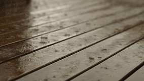 Wooden flooring flooring in rain with scattered water drops. Rainfall covers wooden boards with drops, turning surface into reflective wet background. rainy weather, lifestyle detail. - Powered by Shutterstock - Get 15% off with code: PIKWIZARD15