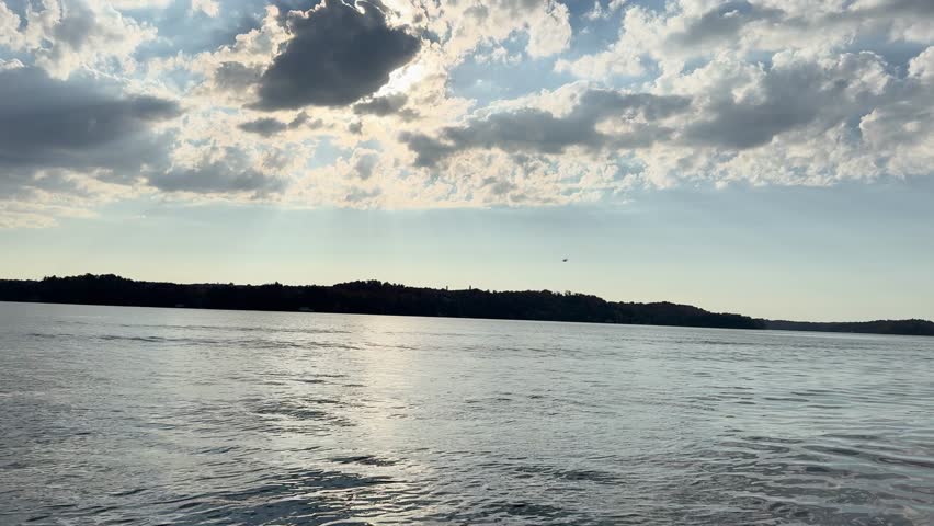 Sunset over calm lake in Muskoka Ontario Canada with soft clouds reflection on water surface, tranquility and mindfulness