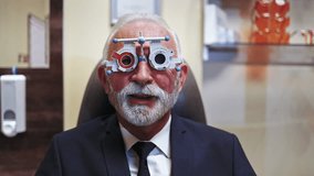 Professional optometrist examining a senior patient's vision with a phoropter trial frame during an appointment in the ophthalmology clinic, selecting the correct lenses for prescription glasses - Powered by Shutterstock - Get 15% off with code: PIKWIZARD15