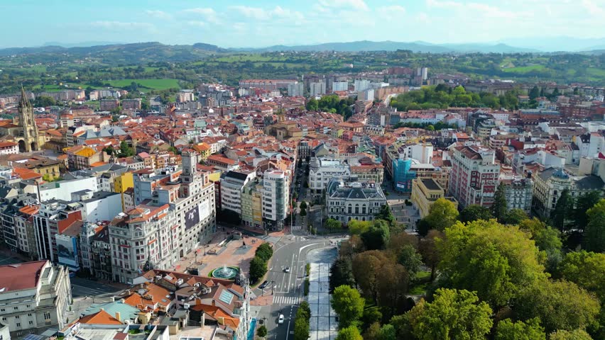 Aerial view of Oviedo, Spain, showcasing its vibrant urban landscape, historic architecture, and the lush Parque de San Francisco under an autumn sky.